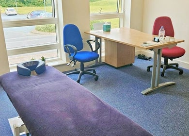 Interior of CGS Sports Therapy in Ludlow, England, GB with a therapy table and chairs by the window.