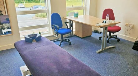 Interior of CGS Sports Therapy in Ludlow, England, GB with a therapy table and chairs by the window.