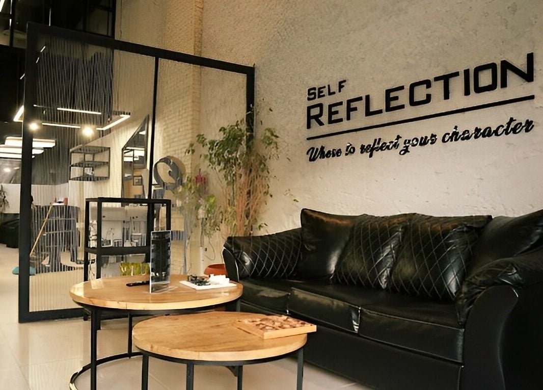 Stylish interior of Self Reflection Barbershop, الرياض, منطقة الرياض, SA featuring a plush black sofa and modern decor.