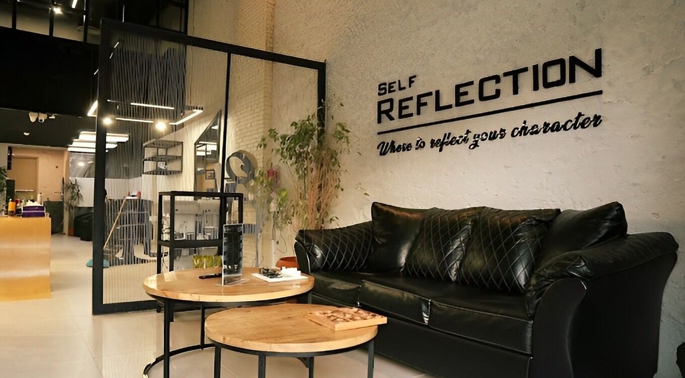 Stylish interior of Self Reflection Barbershop, الرياض, منطقة الرياض, SA featuring a plush black sofa and modern decor.