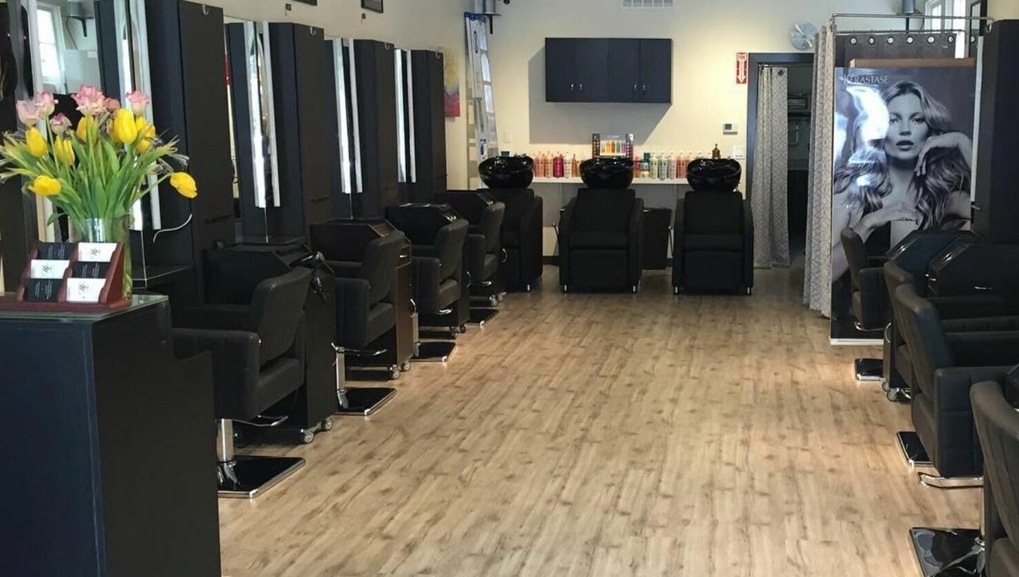Contemporary styling stations at ML Hair Studio, San Francisco, California, US, with sleek black chairs and floral decor.
