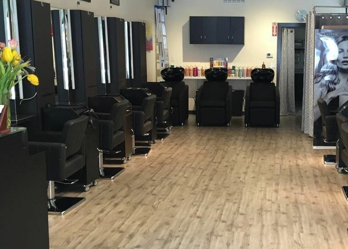 Contemporary styling stations at ML Hair Studio, San Francisco, California, US, with sleek black chairs and floral decor.