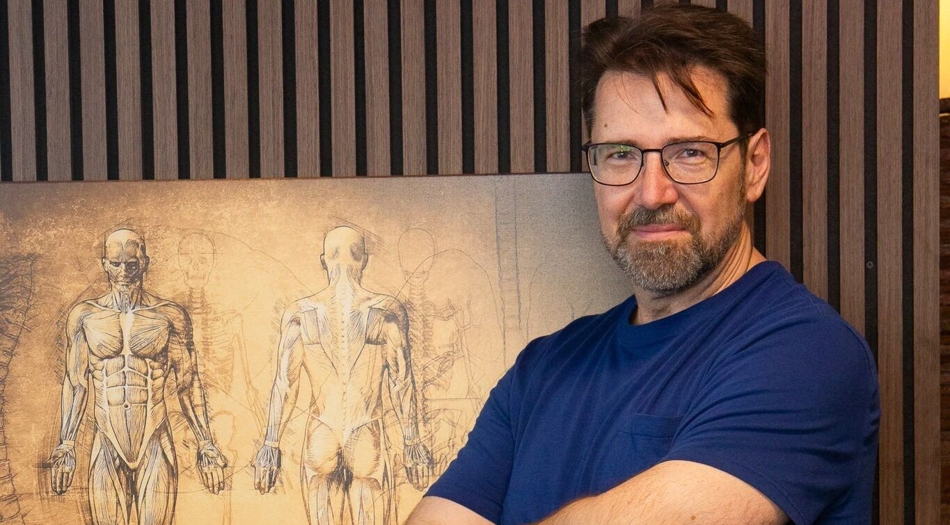 Expert at L.A Sports Recovery, Los Angeles with anatomy art illustrating 'movement is life' concept.