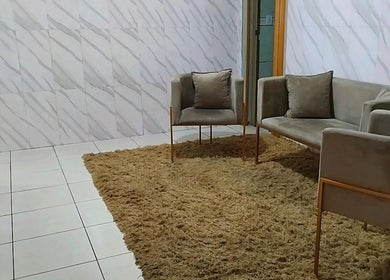 Sala de espera elegante no Espaço Antonella, São Paulo, São Paulo, BR, com sofás em tom neutro.