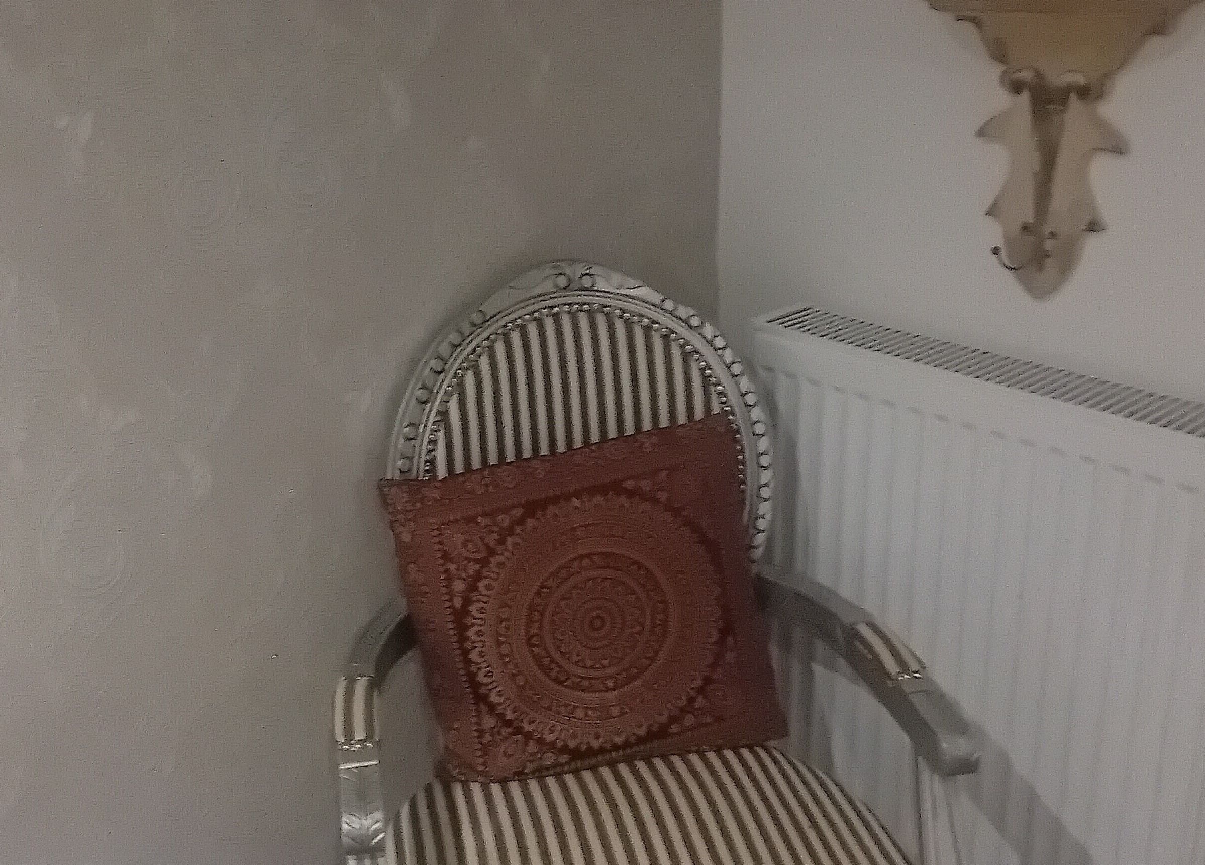 Elegant chair with intricate cushion at Holisticlisa, Douglas, Onchan, IM. Perfect relaxation spot.