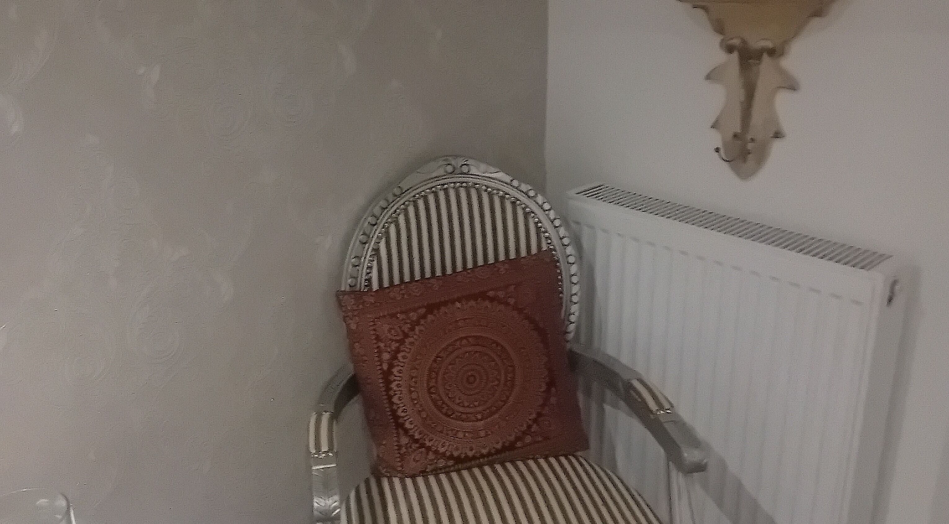 Elegant chair with intricate cushion at Holisticlisa, Douglas, Onchan, IM. Perfect relaxation spot.