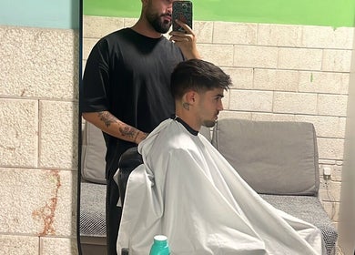 Κομμωτής προετοιμάζει κούρεμα στο Buzz Bangs Concept, Λεμεσός, CY.