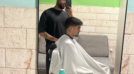 Κομμωτής προετοιμάζει κούρεμα στο Buzz Bangs Concept, Λεμεσός, CY.