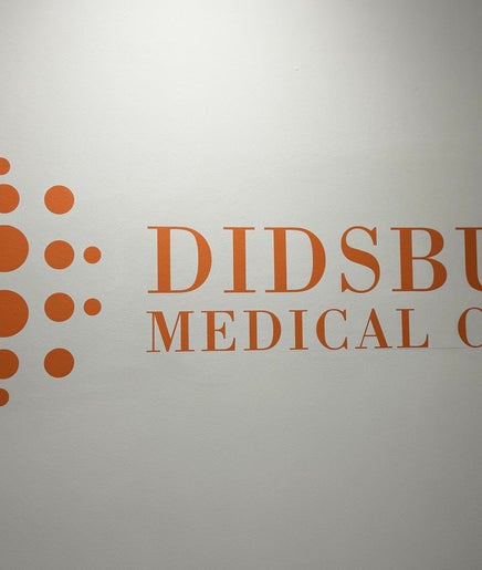 Logo of Didsbury Medical Clinic on a wall, located in Manchester, England, GB.