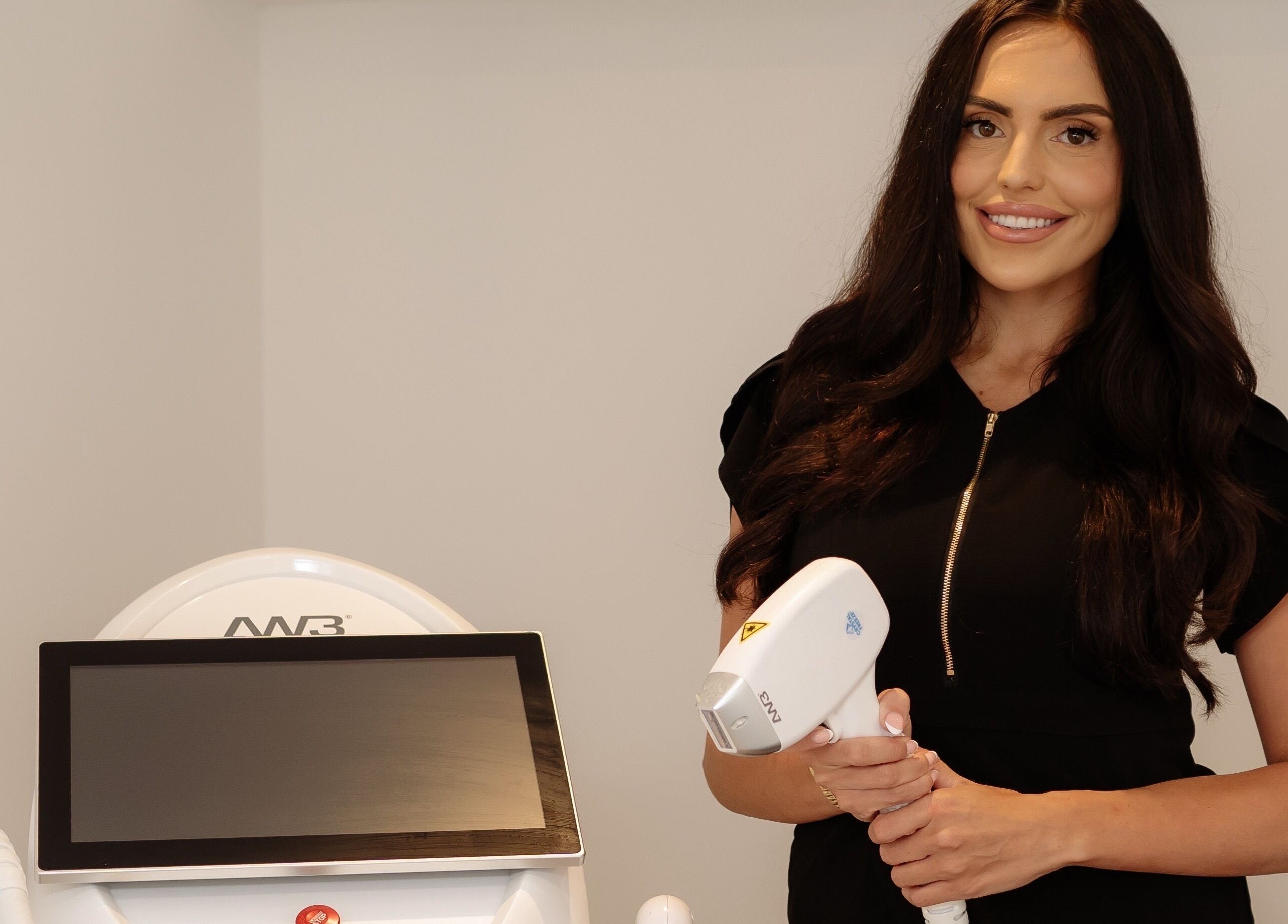 Professional at Radiance Laser Studio in Aberdeen, Scotland, GB holding laser equipment, ready for treatment.