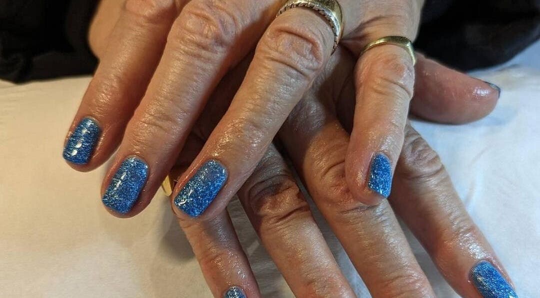Blue glitter manicure at Andreas Hands and Tans in Stevenage, England, GB, showcasing stylish nail care.