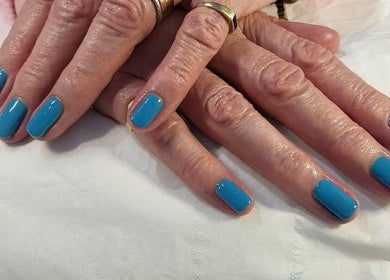 Bright blue manicured nails at Andreas Hands and Tans, Stevenage, England, GB.