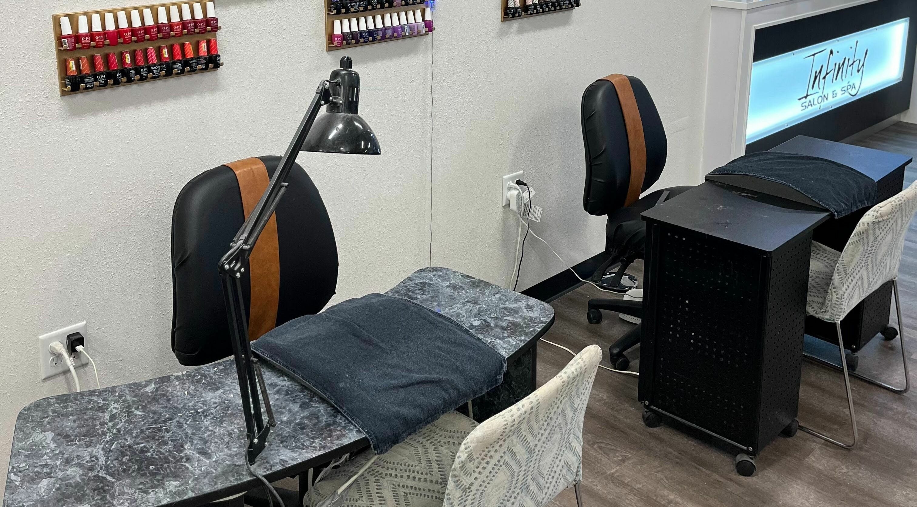 Modern nail stations at Infinity Salon and Spa, Mitchell, South Dakota, US, showcasing diverse polish selection.