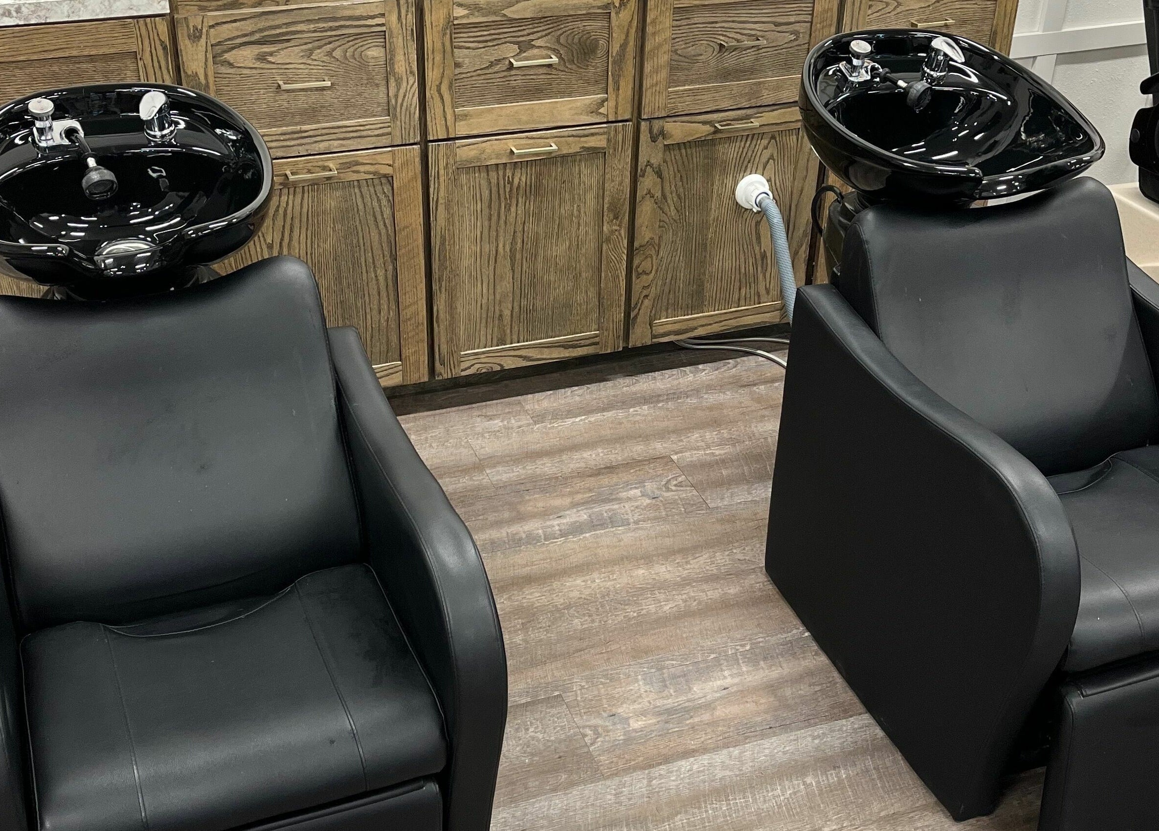 Two modern wash stations at Infinity Salon and Spa in Mitchell, South Dakota, US, featuring black chairs.