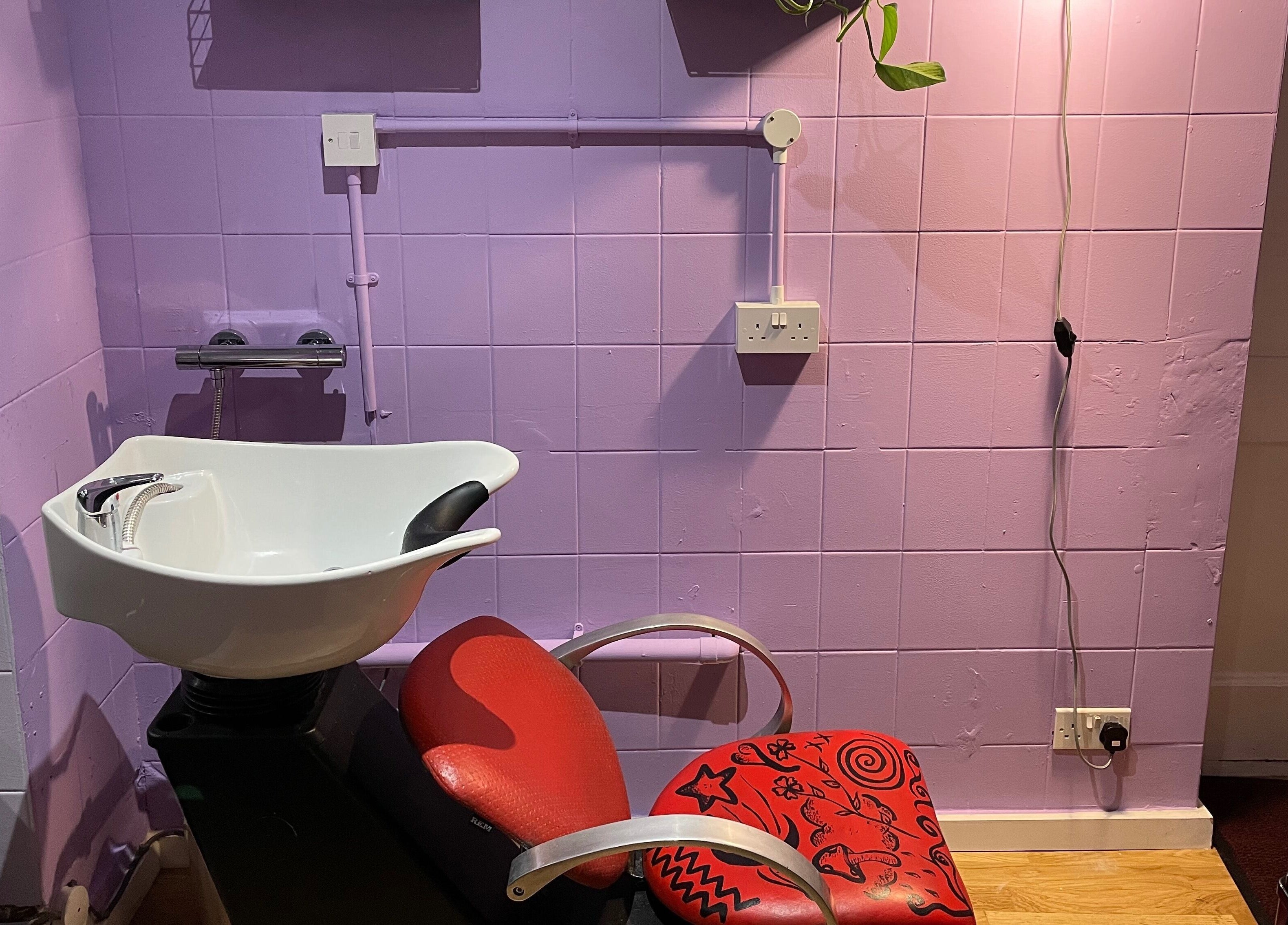 Modern salon chair at Go Coiff Yourself, Brighton And Hove, England, GB. Purple walls enhance the chic vibe.