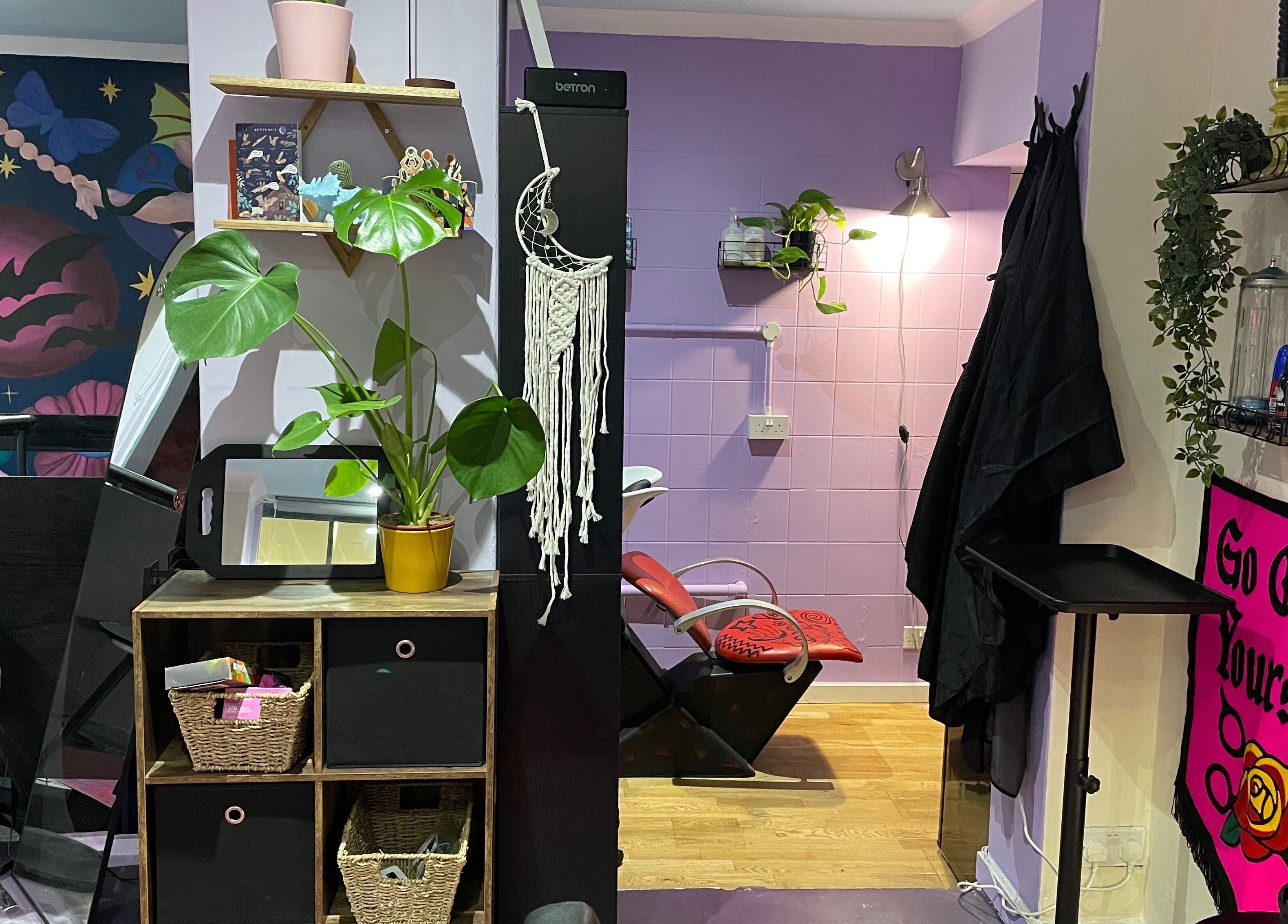 Eclectic interior of Go Coiff Yourself, Brighton And Hove, England, GB with vibrant decor and styling chairs.