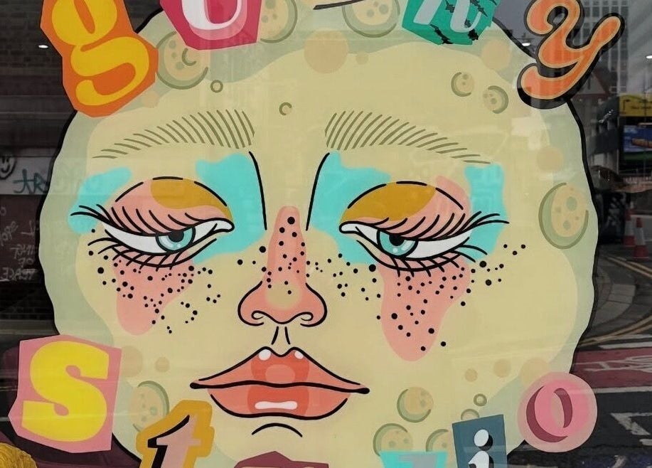 Colorful street art at Go Coiff Yourself, Brighton And Hove, England, GB, showcasing a creative face design.