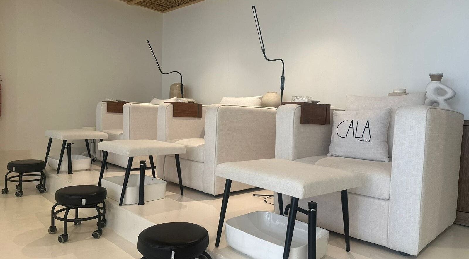 Elegant seating at CALA nail bar in Riyadh, Riyadh Province, SA showcasing plush armchairs and footrests.