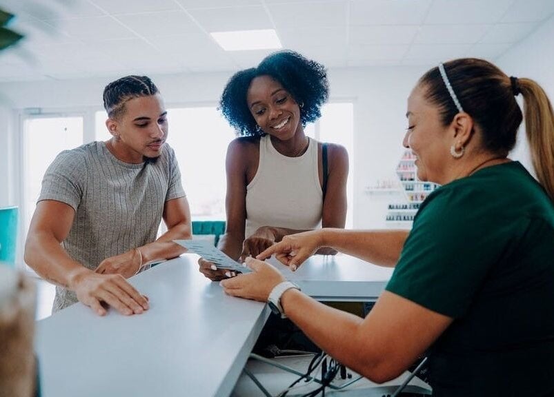 Guests at the reception of Kundalini Spa, Noord, AW, receiving warm assistance from staff.