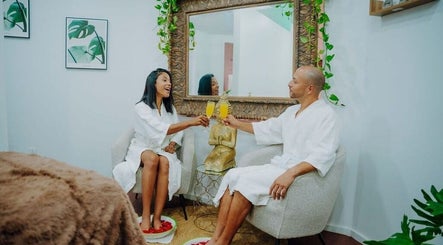 Couple enjoying relaxation at MASSAGE THERAPY KUNDALINI, Noord, AW, sipping drinks in cozy lounge.