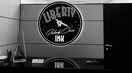 Reception moderna di Liberty Ink Tattoo & Piercing a Firenze, Toscana, IT, con logo luminoso.