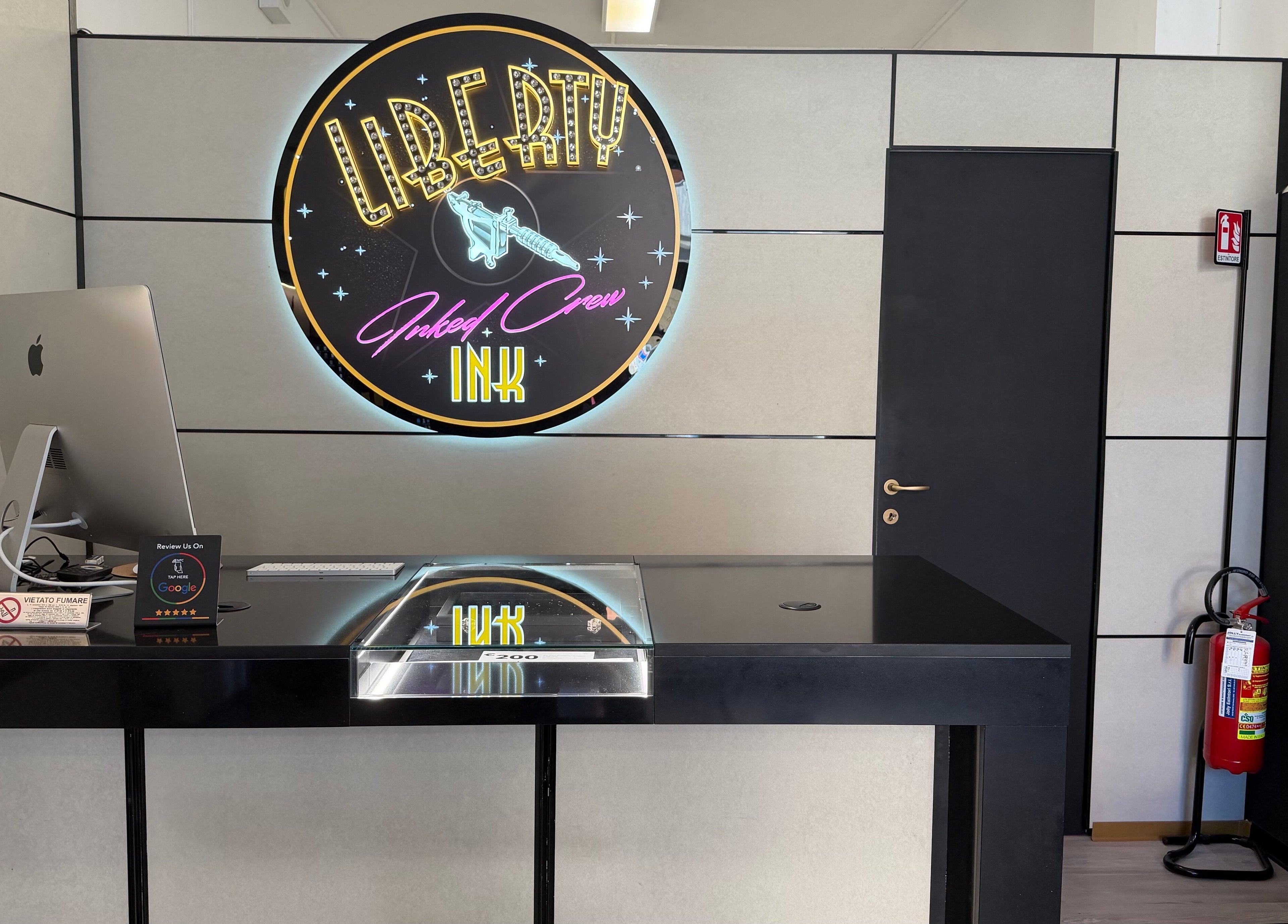 Reception moderna di Liberty Ink Tattoo & Piercing a Firenze, Toscana, IT con logo luminoso.