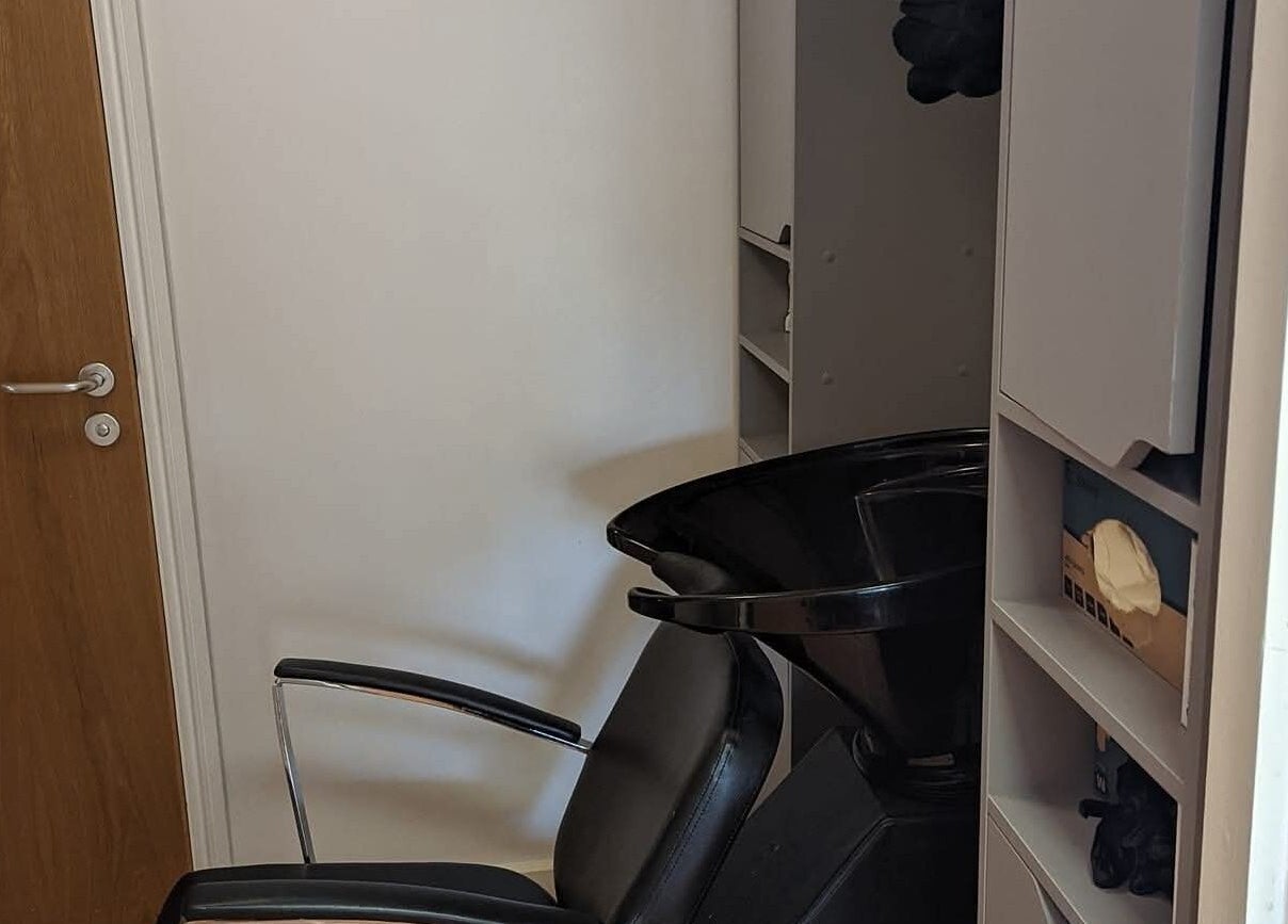Hair washing station at chloenortonhair in Dereham, England, GB, featuring a sleek black chair and wash basin.