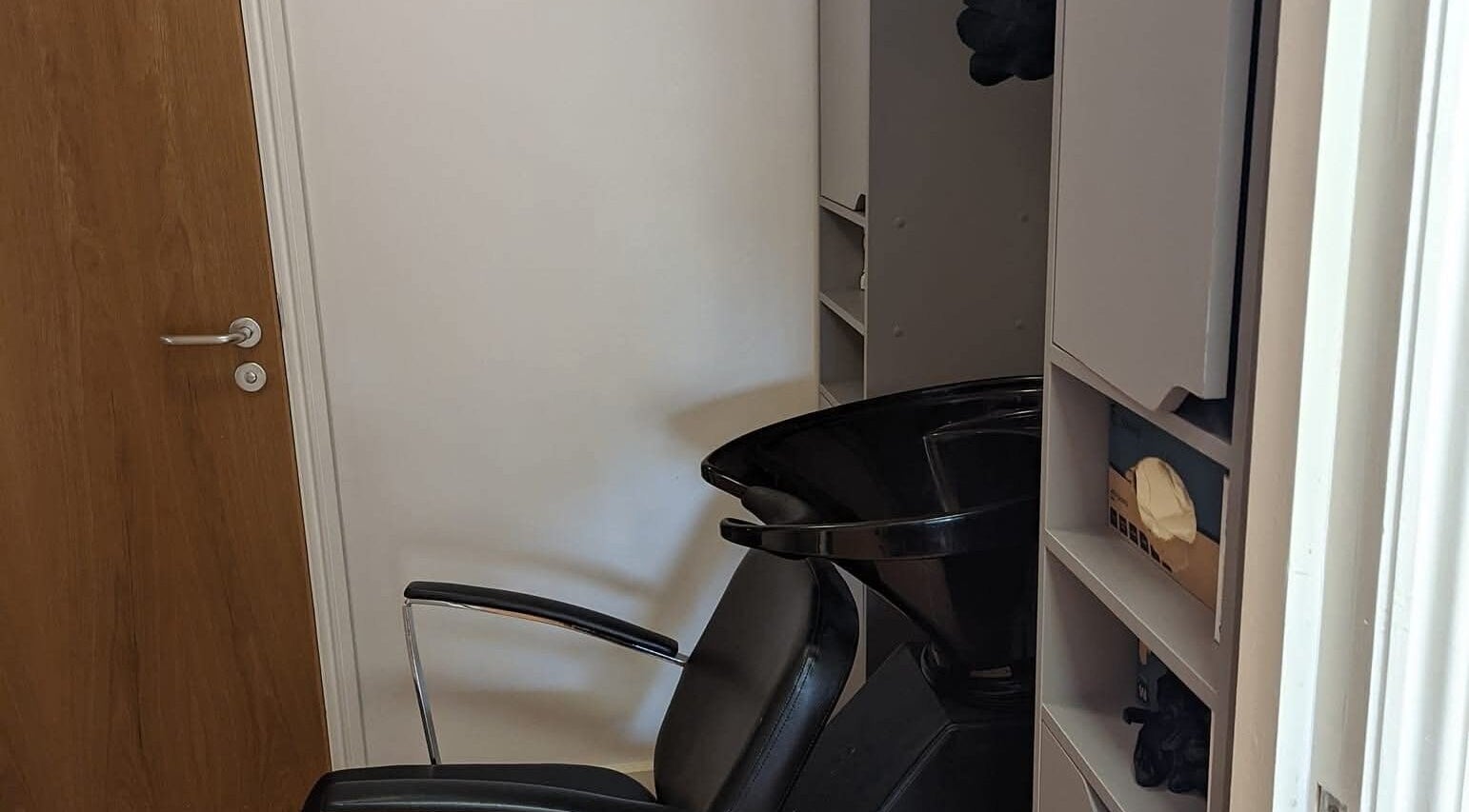 Hair washing station at chloenortonhair in Dereham, England, GB, featuring a sleek black chair and wash basin.