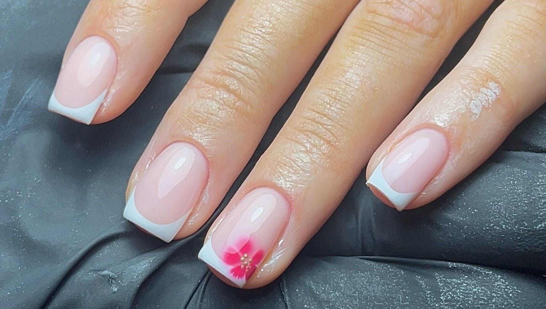 French manicure with pink flower accent at Coco Nail Studio, Cardiff, Wales, GB.