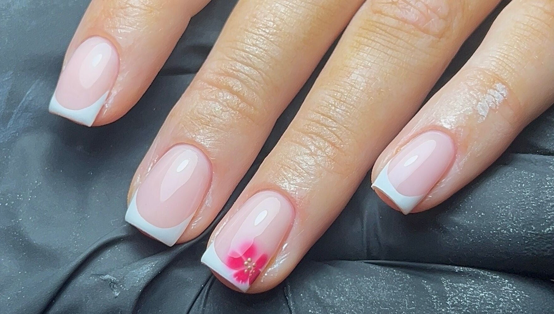 French manicure with pink flower accent at Coco Nail Studio, Cardiff, Wales, GB.