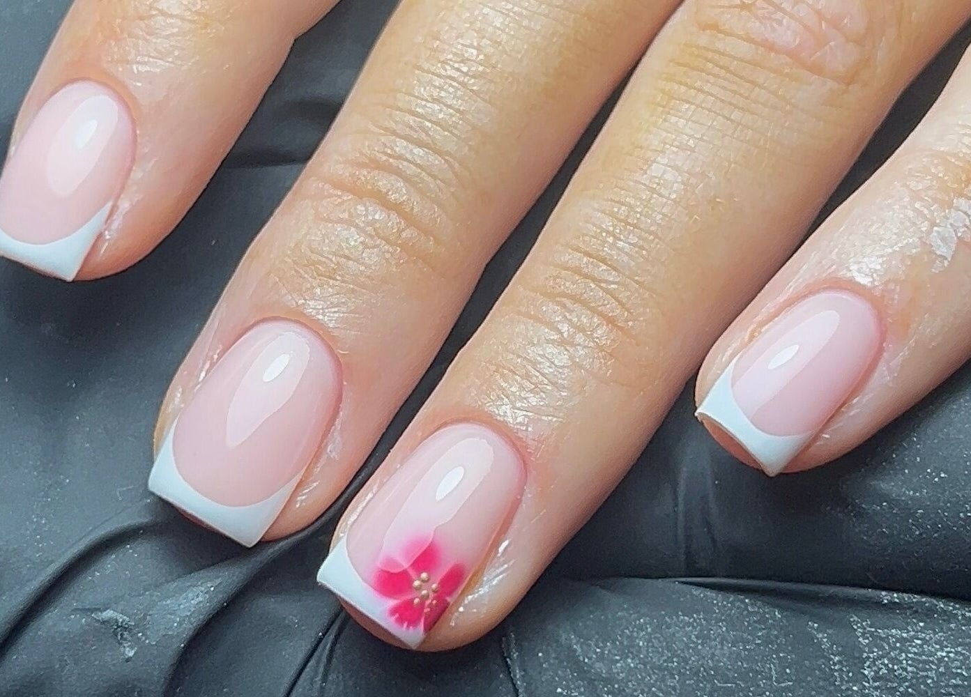 French manicure with pink flower accent at Coco Nail Studio, Cardiff, Wales, GB.