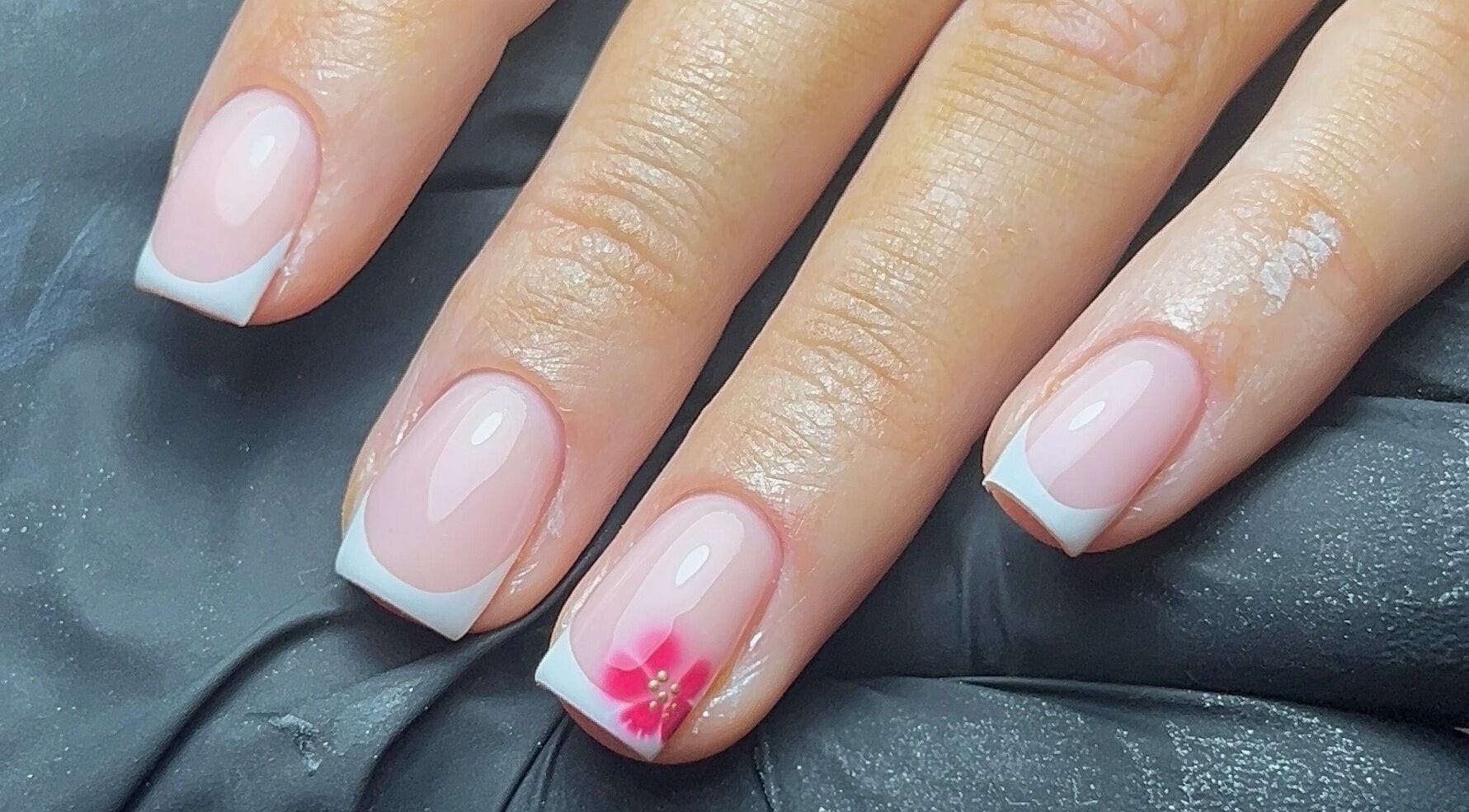 French manicure with pink flower accent at Coco Nail Studio, Cardiff, Wales, GB.