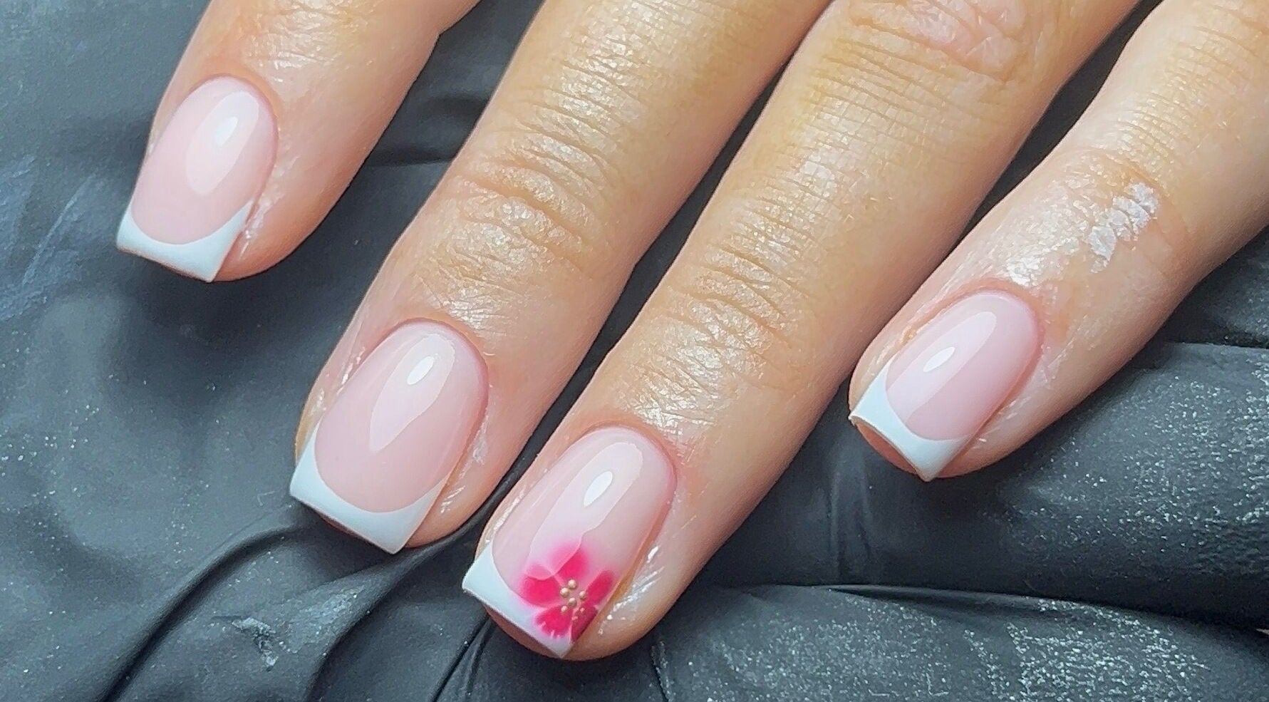 French manicure with pink flower accent at Coco Nail Studio, Cardiff, Wales, GB.
