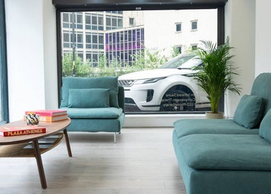 Modern lounge area of Cryo Revive Manchester with teal sofas and potted plants, located in Manchester, England, GB.