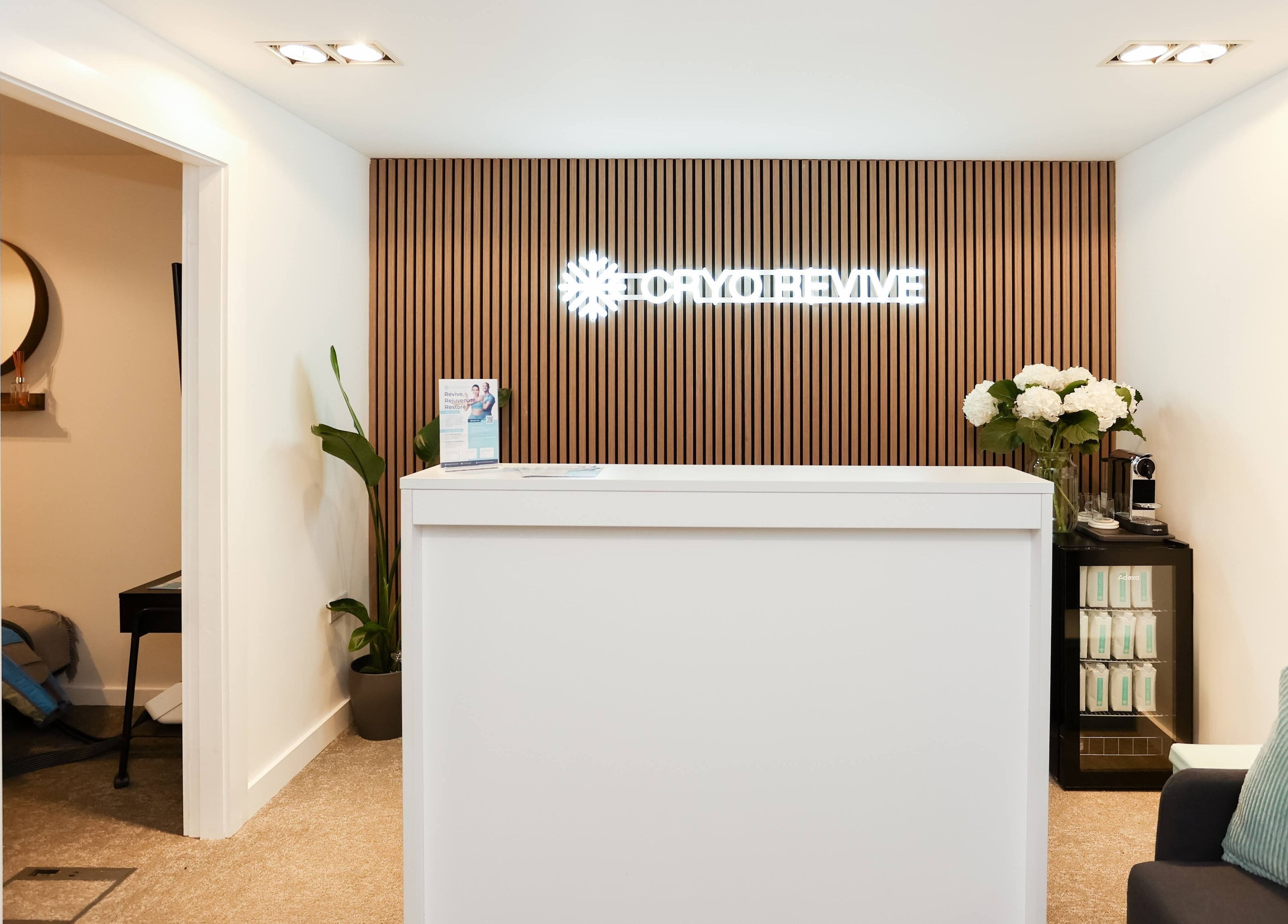 Reception desk at Cryo Revive Wilmslow, Wilmslow, England, GB, featuring modern decor and warm ambiance.