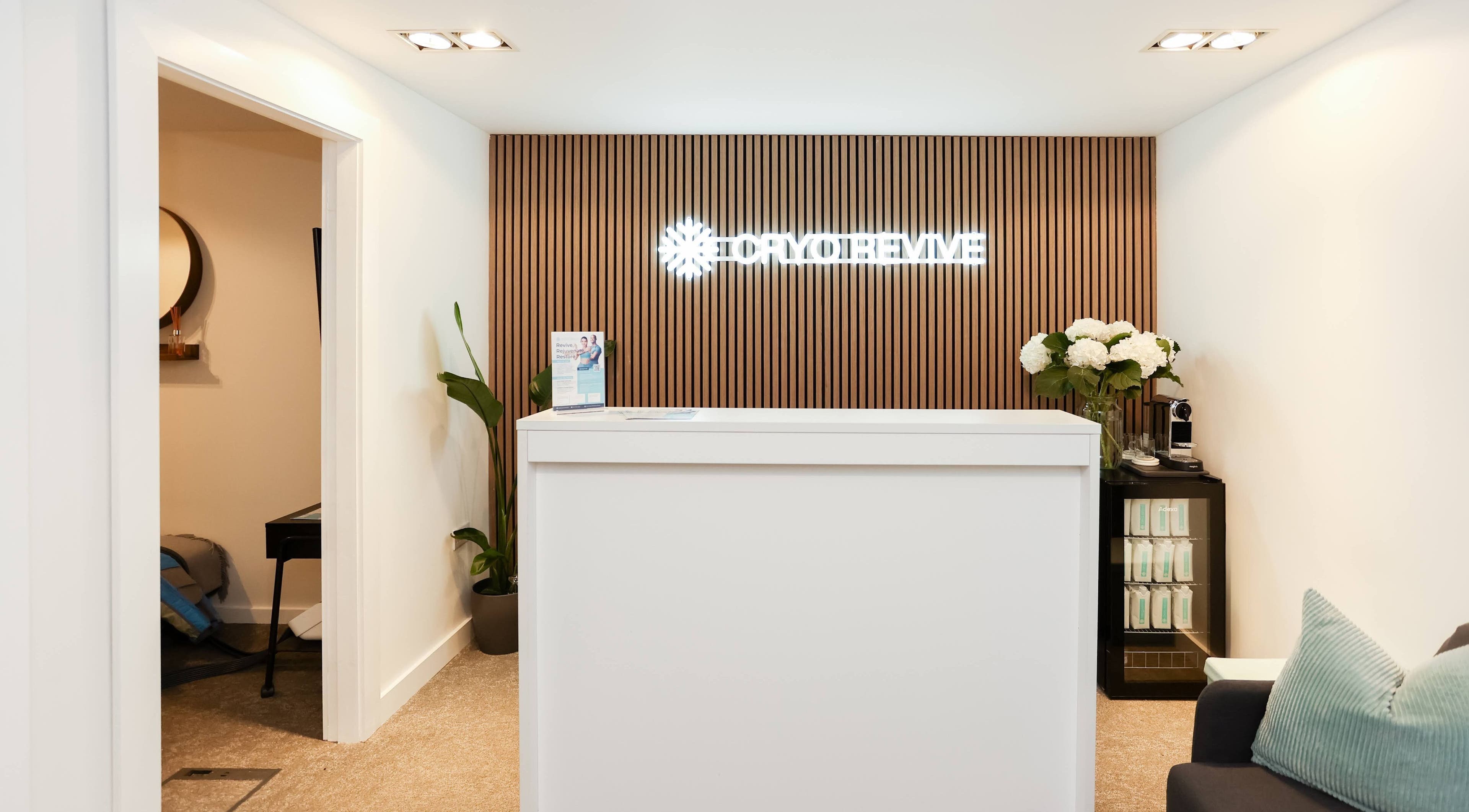 Reception desk at Cryo Revive Wilmslow, Wilmslow, England, GB, featuring modern decor and warm ambiance.