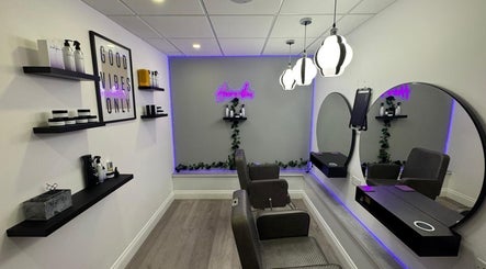 Modern salon interior at Hairvibes, Hazlemere, England with stylish decor and neon sign.