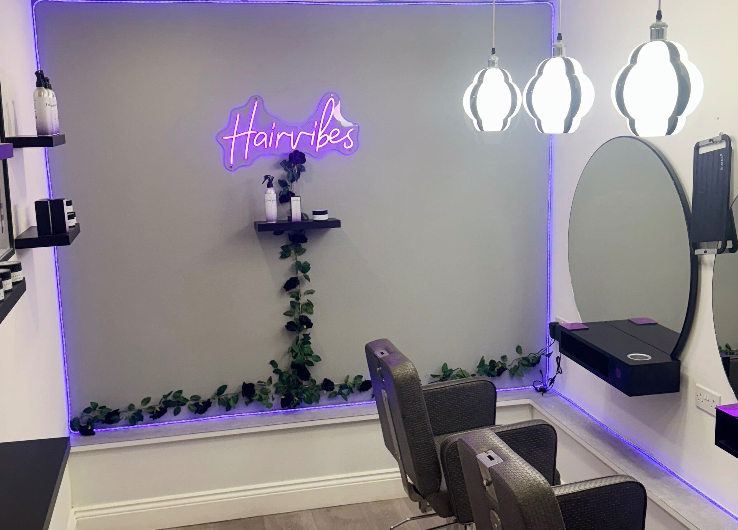 Modern salon interior at Hairvibes, Hazlemere, England, GB, featuring chic mirrors and ambient lighting.