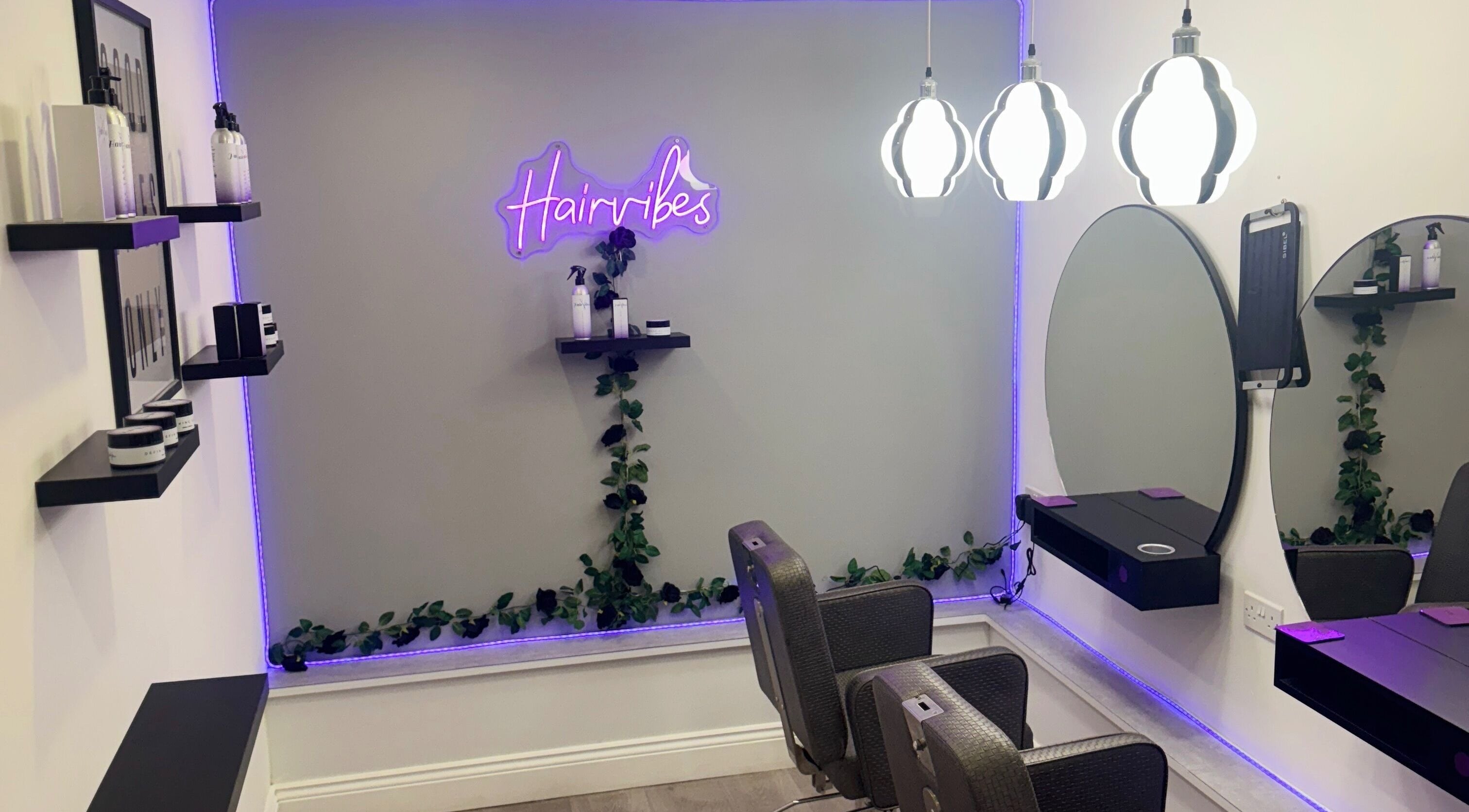 Modern salon interior at Hairvibes, Hazlemere, England, GB, featuring chic mirrors and ambient lighting.