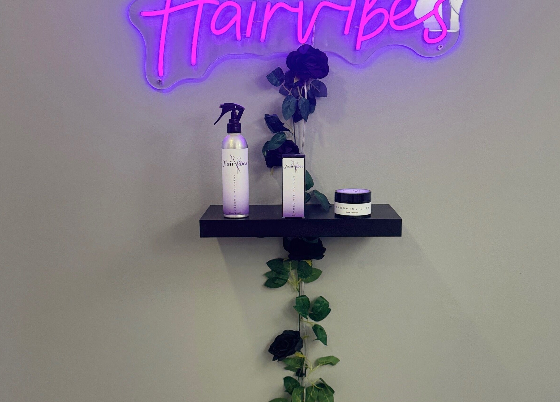 Hairvibes wall display with hair products in Hazlemere, England, GB. Vibrant purple sign and elegant decor.