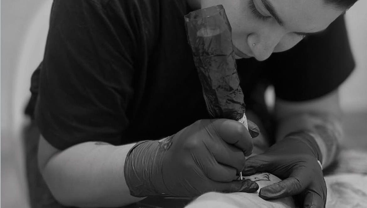 Artista tatuando cuidadosamente en Adasat Studio, Canarias, Canarias, ES.