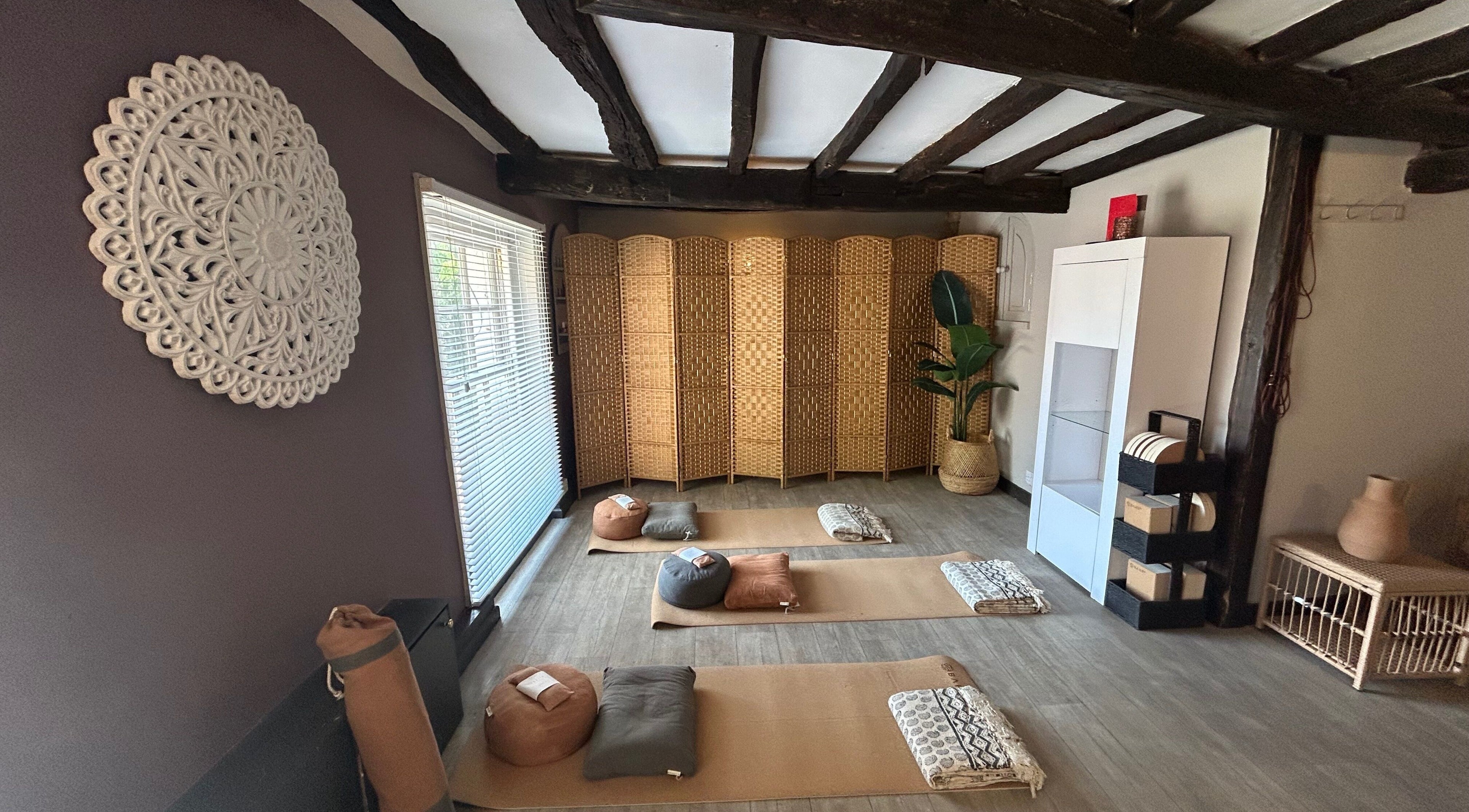 Cozy meditation room at Sanctum in Lincoln, England, GB with mats and woven decor for relaxation and tranquility.