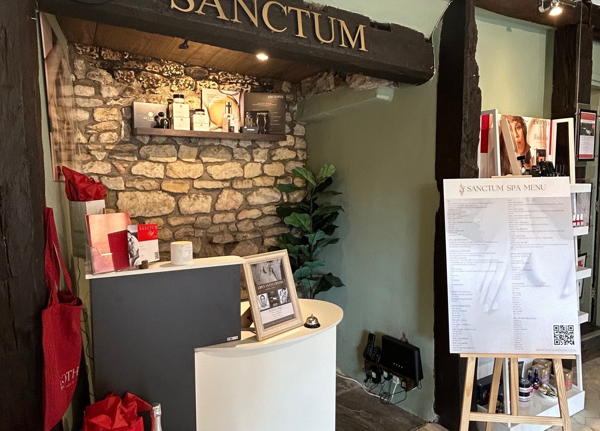 Reception area of Sanctum in Lincoln, England, showcasing spa menu and decor.