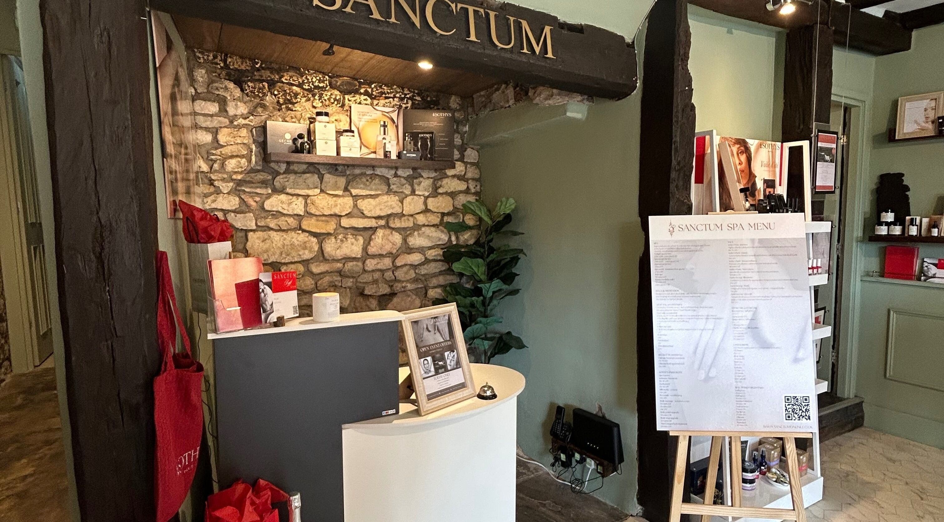 Reception area of Sanctum in Lincoln, England, showcasing spa menu and decor.