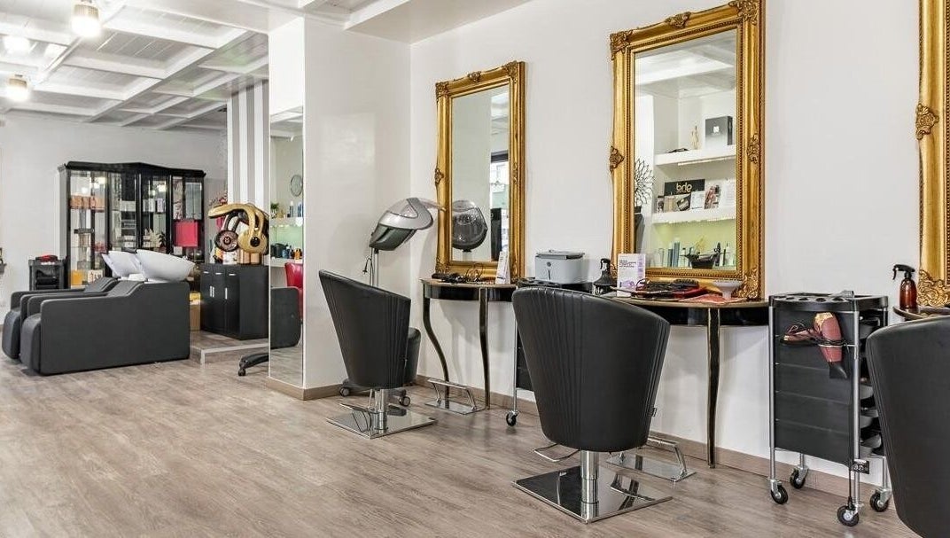 Interno sofisticato di Venere Parrucchieri, Alghero, Sassari, IT, con eleganti specchi dorati.