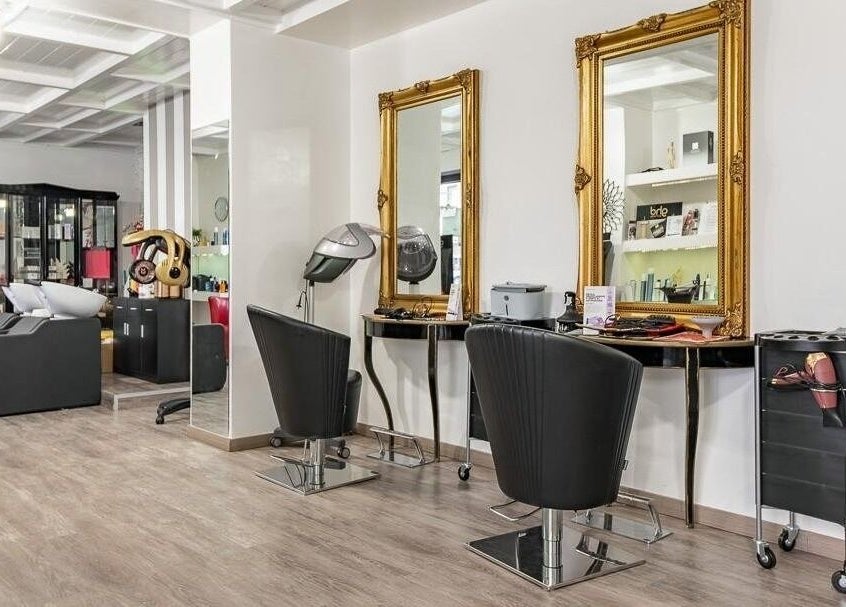Interno sofisticato di Venere Parrucchieri, Alghero, Sassari, IT, con eleganti specchi dorati.
