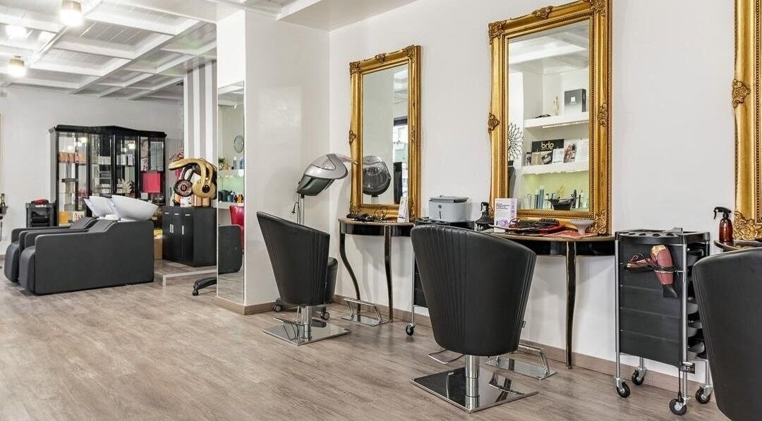 Interno sofisticato di Venere Parrucchieri, Alghero, Sassari, IT, con eleganti specchi dorati.
