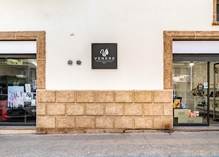 Facciata di Venere Parrucchieri ad Alghero, Sassari, IT, con vetrine moderne e insegna elegante.