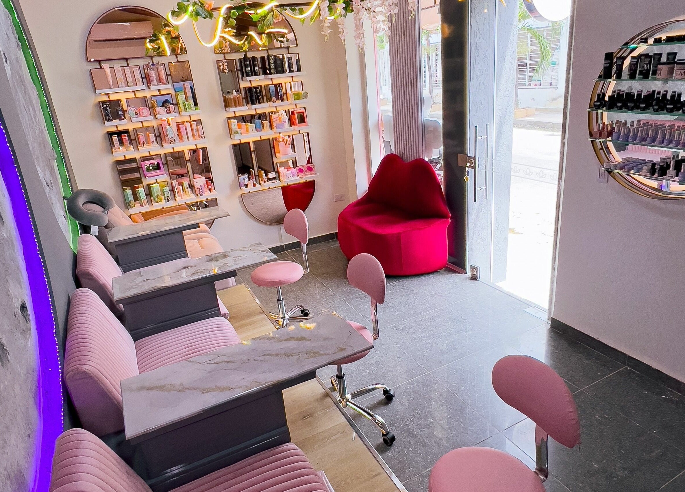 Interior moderno de Shanti Beauty en Cúcuta, Norte De Santander, CO con sillas rosadas y estantes iluminados.