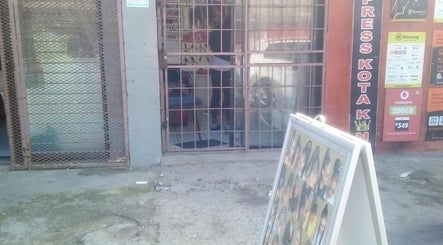 Entrance of G&L Hair Salon And Nails, Cape Town, showcasing exterior signage and hairstyle posters.